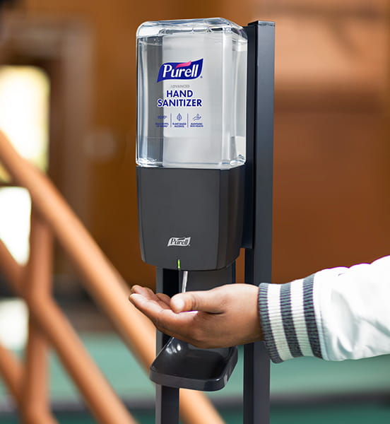 Automatic hand sanitizer dispenser dispensing solution to hand.