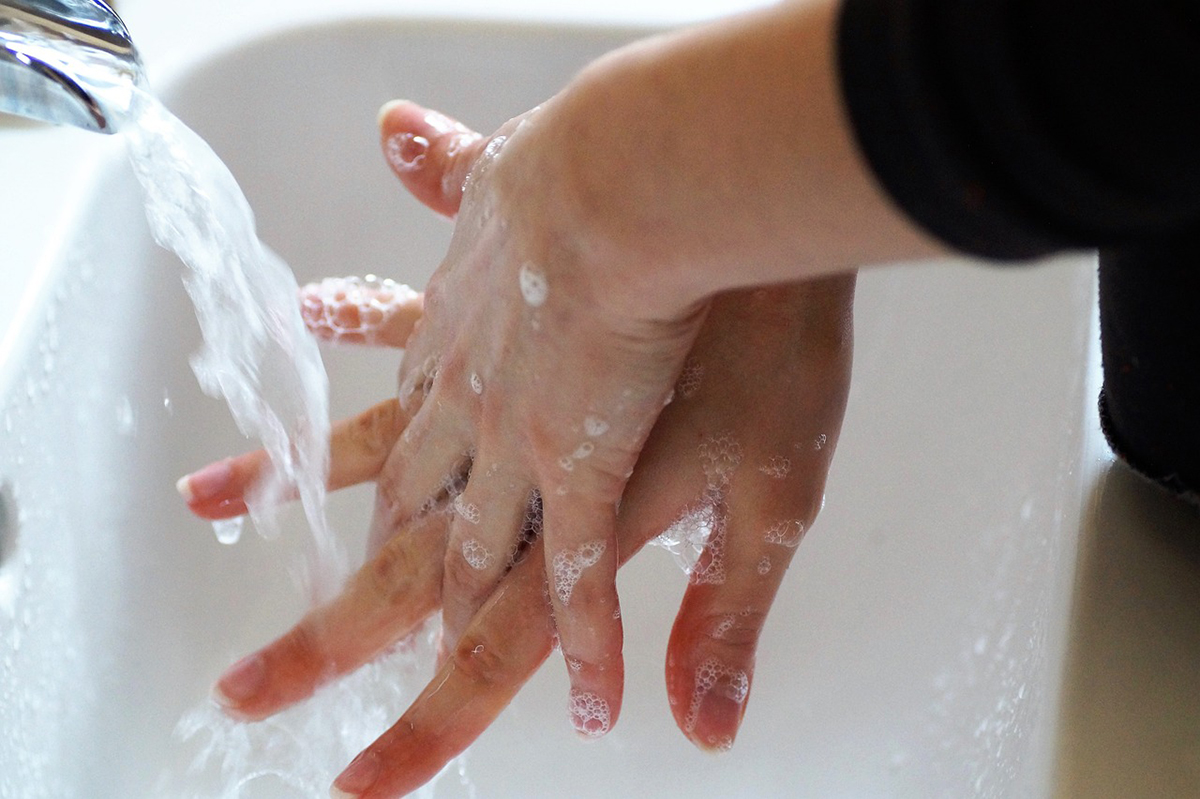 soapy lathered hands above sink