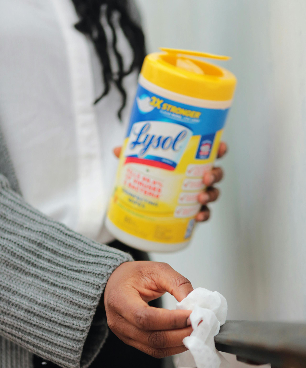 woman using lysol wipes in a container